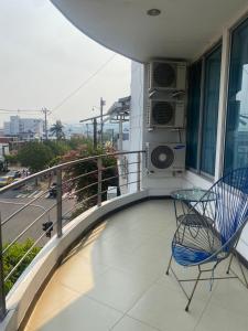 Un balcón con una silla azul y una mesa de cristal en Hotel Milenium, en Yopal