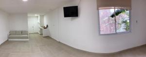 a living room with a couch and a television on a wall at GMP Suites in San Miguel de Tucumán