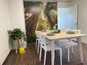 uma sala de jantar com uma mesa com cadeiras brancas em Coastal Motel em Apollo Bay