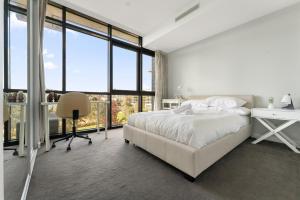 a bedroom with a bed and a desk and windows at Stylish 2-Bed with Amenities 10-Min from CBD in Campbell