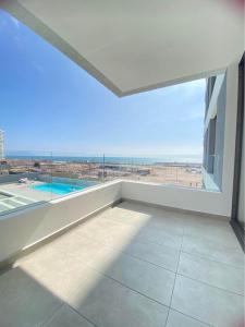 een lege kamer met een groot raam en uitzicht op de oceaan bij Edif Roble in Antofagasta