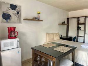 a small kitchen with a table and a microwave at Suite Noa Apartamento in San Pedro Sula