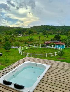 bañera en una terraza de madera con un campo en Rancho Navarro, en Porto de Pedras