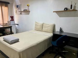 a bedroom with a bed and a desk and a chair at Suite Noa Apartamento in San Pedro Sula