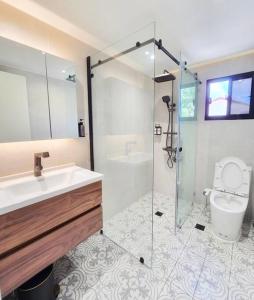 a bathroom with a shower and a sink and a toilet at Kiddie Hostel Unit 30B-kids and pets friendly in Subic bay freeport zone in Kababae