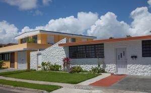 uma casa com um amarelo e branco em Safe Quiet Apartments Near Airport em Carolina