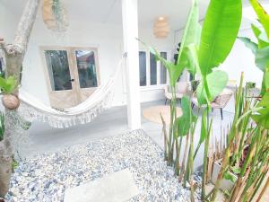 3BR Villa, Bangrak Beach, Koh Samui في كوه ساموي: غرفة بها أرجوحة وبعض النباتات