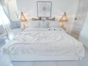 a white bedroom with a large bed with white sheets at 3BR Villa, Bangrak Beach, Koh Samui in Koh Samui 