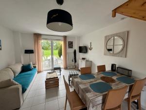a living room with a table and a couch at Maison 2 chambres au calme avec piscine, proche plages et commerces - FR-1-197-484 in Talmont-Saint-Hilaire
