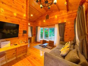 a living room with a couch and a television in a cabin at Soundless Resort in Khao Kho