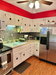 a kitchen with white cabinets and a stainless steel refrigerator at Family Friendly Downtown Home - Private Yard & Grill - Location, Location, Location! in Athens