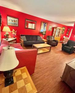 a living room with red walls and black furniture at Family Friendly Downtown Home - Private Yard & Grill - Location, Location, Location! in Athens