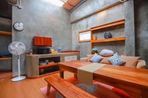 een woonkamer met een tafel en een keuken bij Soundless Resort in Khao Kho