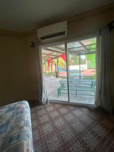 een slaapkamer met een glazen schuifdeur naar een patio bij VLR habitaciones in La Ceiba