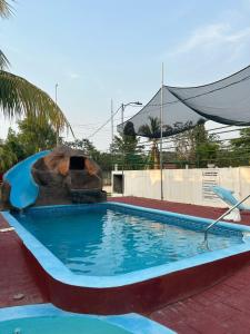 einen Pool in einem Resort mit einer Wasserrutsche in der Unterkunft VLR habitaciones in La Ceiba