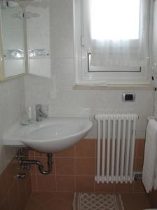 a bathroom with a sink and a window and a radiator at Alphotel Milano in Andalo +37 photos