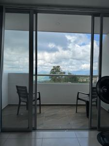 d'un balcon avec deux chaises et une vue sur l'océan. dans l'établissement Apto panoramico. La mesa-cundinamarca, à La Mesa