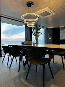 a dining room with a table and chairs and a chandelier at private villa クニウミ之チ in Awaji
