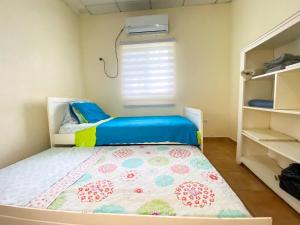 niewielka sypialnia z łóżkiem i oknem w obiekcie Oasis de Tranquilidad w mieście Colón
