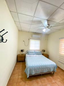 sypialnia z łóżkiem i wentylatorem sufitowym w obiekcie Oasis de Tranquilidad w mieście Colón