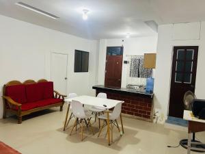 un soggiorno con divano rosso, tavolo e sedie di Departamento de 3 habitaciones a Pucallpa
