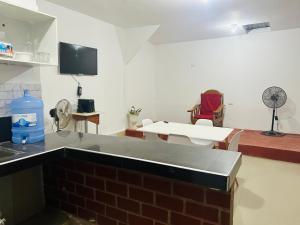 a kitchen with a counter top and a room with a fan at Departamento de 3 habitaciones in Pucallpa