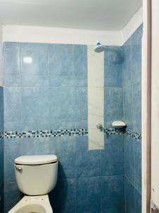uma casa de banho com azulejos azuis e um WC. em Departamento de 3 habitaciones em Pucallpa
