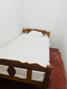 Departamento de 3 habitaciones في بوكالبا: سرير في زاوية من الغرفة