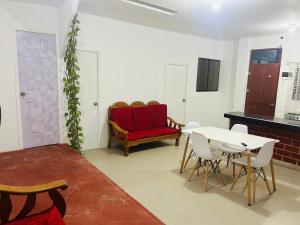 Departamento de 3 habitaciones في بوكالبا: غرفة معيشة مع أريكة حمراء وطاولة