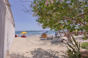 a beach with people sitting on the sand and the ocean at Lujoso Apartamento con salida a la playa in Cartagena de Indias