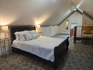 una camera da letto con un grande letto con lenzuola e cuscini bianchi di France and Flowers Guest House a Stratford