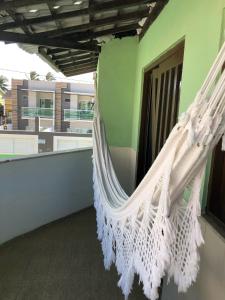 a white hammock hanging on a balcony at “Mar doce Lar” in Lauro de Freitas
