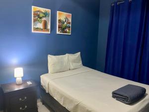 a bedroom with a bed and a blue wall at Horus Suite Apartamento in San Pedro Sula
