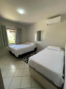 1 dormitorio con 2 camas y ventana en Colione House, en Balneário Camboriú