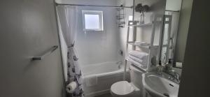 un bagno bianco con doccia e lavandino di Two Bedroom Serenity with AC- Complimentary Welcome Treats a Langford