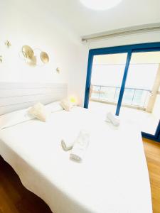 um quarto com uma cama branca e uma janela em Villa Puerto Beach vistas al mar em Altea