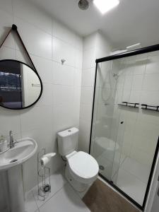 a white bathroom with a toilet and a shower at Studio Lupi in Sao Paulo