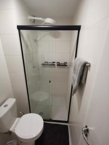 a bathroom with a toilet and a glass shower at Studio Lupi in Sao Paulo