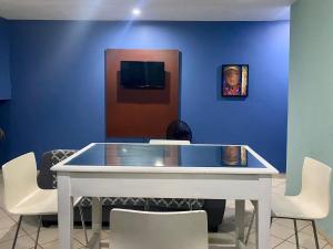 a blue room with a white table and chairs at Horus Suite Apartamento in San Pedro Sula