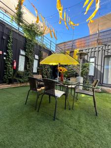 une terrasse avec une table, des chaises et un parasol dans l'établissement Colmena House Villa Alemana, à Villa Alemana