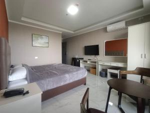a hotel room with a bed and a desk and a tv at Blue Hotel and Resort in Porac