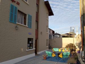 a group of tables and chairs on a patio next to a building at Hotel El Gallego in El Quisco
