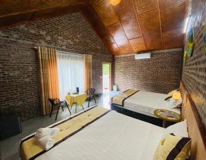 a room with two beds and a table with chairs at TamCoc Việt Tân Homestay & Garden in Ninh Binh