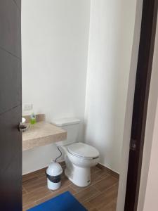 a bathroom with a white toilet in a room at Departamento Bohen 13 in Mérida