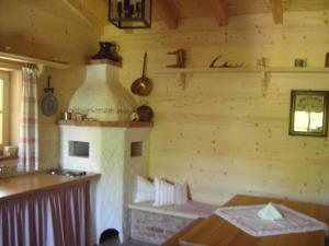 a kitchen with a stove in a log cabin at Ferienwohnungen Rosenegger in Staudach-Egerndach