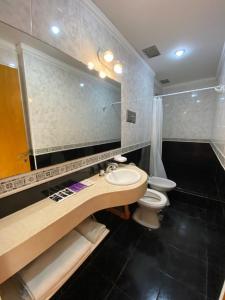 a bathroom with a sink and a toilet and a mirror at HOTEL PALERMO BUENOS AIRES in Buenos Aires