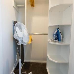 a white fan in a room with a closet at Deluxe Central retreat w/super king bed in Christchurch