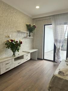 een slaapkamer met een groot raam met bloemen aan de muur bij Three Palms House in Tbilisi City