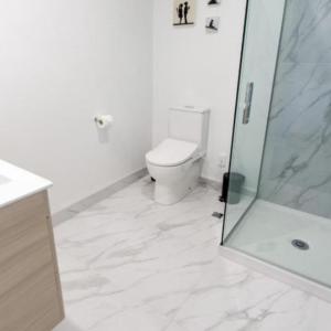 基督城的住宿－Deluxe Central retreat w/super king bed，白色的浴室设有卫生间和淋浴。