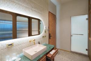 a bathroom with a sink and a mirror at Papoa Harbor Hotel in Kaohsiung